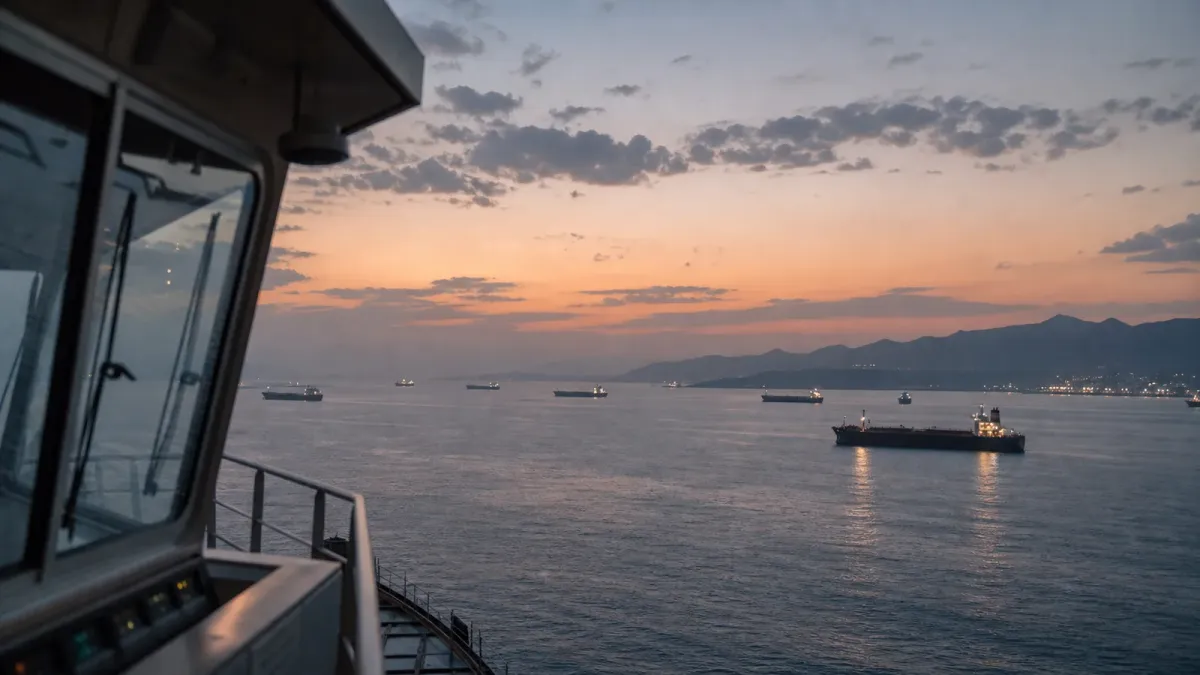 Cargo tankers move through calm water at dusk in a generic maritime shipping lane.