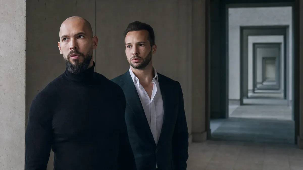 Source-grounded editorial image of Andrew and Tristan Tate beside a stark corridor of repeating doorways
