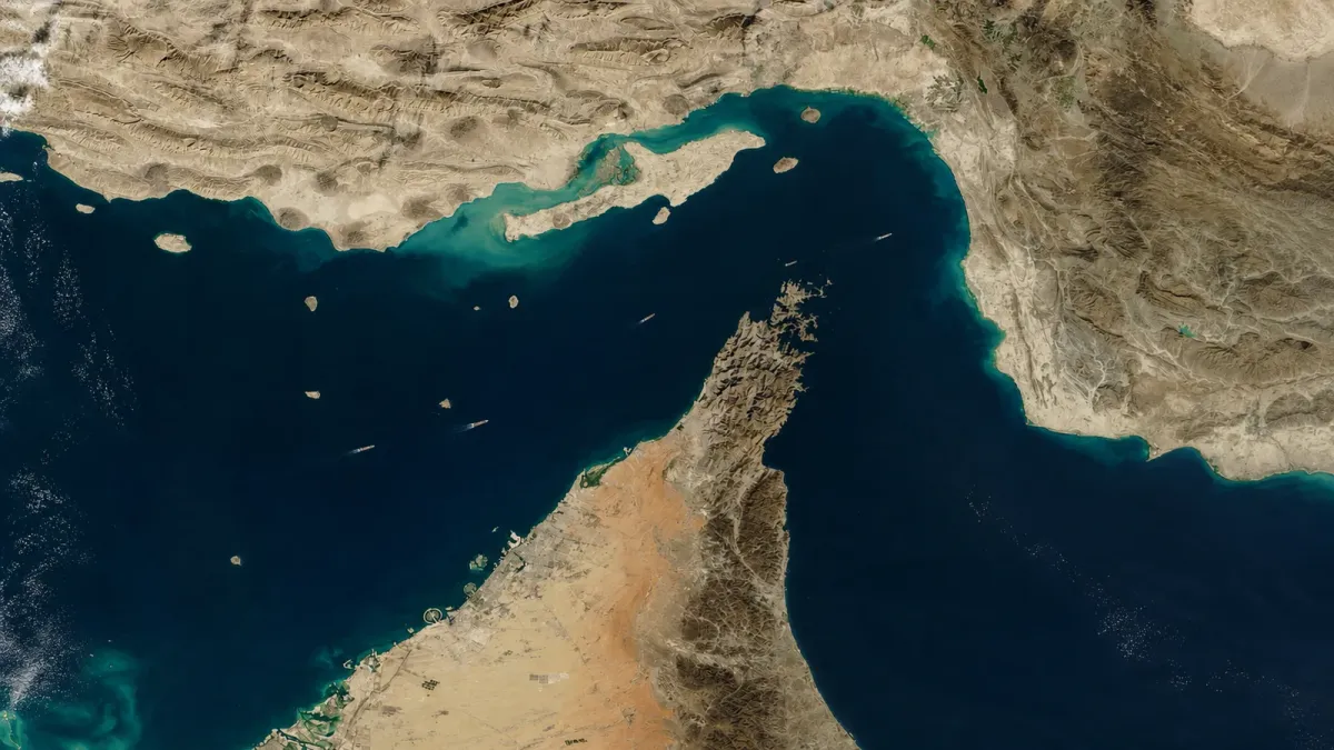 Satellite-style view of the Strait of Hormuz with sparse vessel movement through the narrow waterway