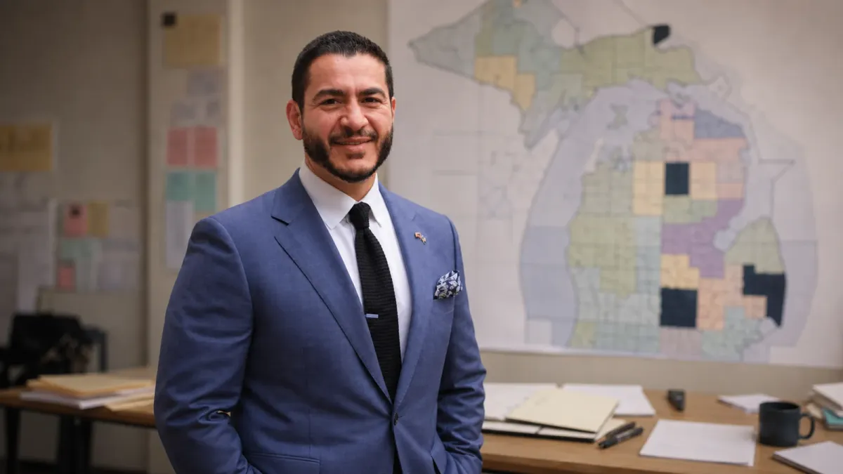Abdul El-Sayed in a campaign setting with a Michigan election map and voter materials behind him
