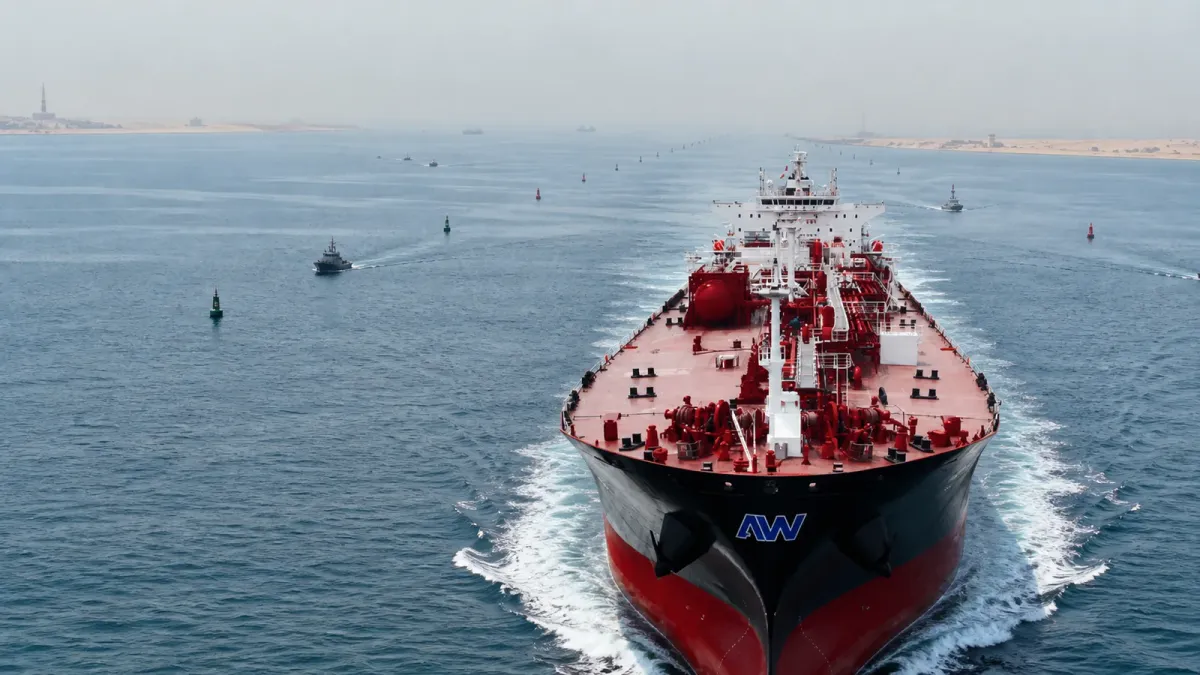 An Abu Dhabi National Oil Company and ADNOC-style tanker moves through open water in a guarded shipping corridor.