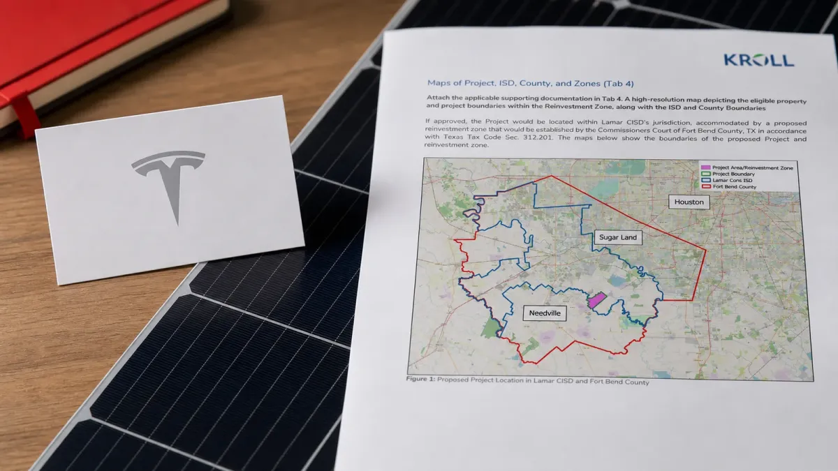 Tesla-branded project papers and a Fort Bend County map arranged over solar-cell material