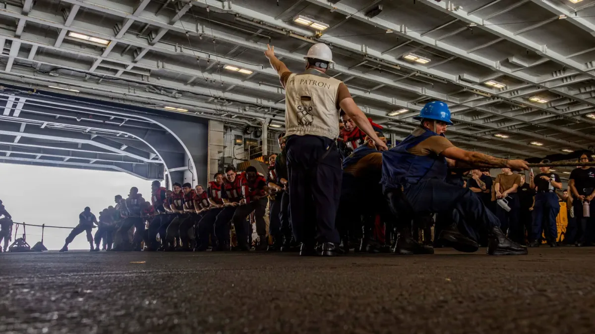 Sailors aboard USS Abraham Lincoln pull a supply line from USNS Cesar Chavez during a replenishment at sea in the Arabian Sea.