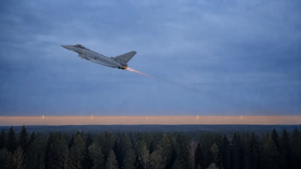 An Italian Eurofighter climbs above a Baltic air base at dawn in an editorial image about Latvia's airspace alert