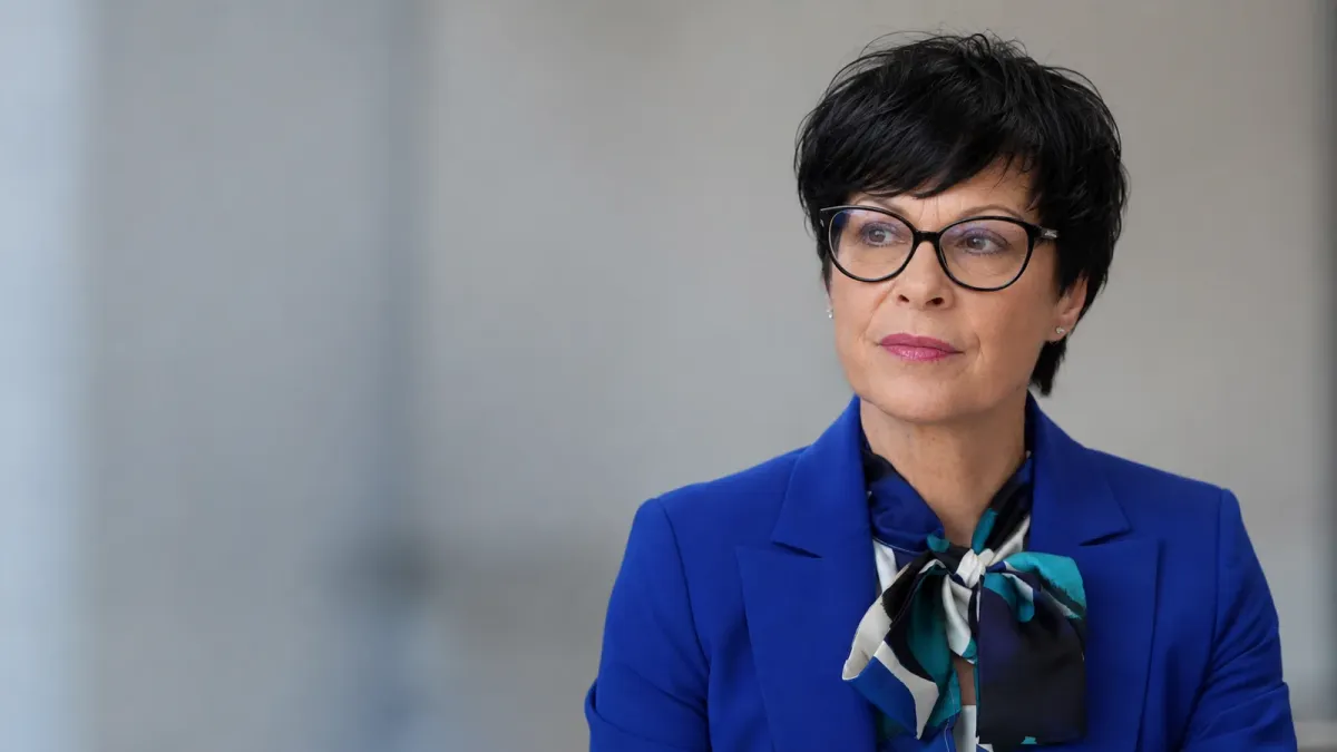 AI-generated editorial portrait of EU enlargement commissioner Marta Kos, who canceled her planned Serbia visit.
