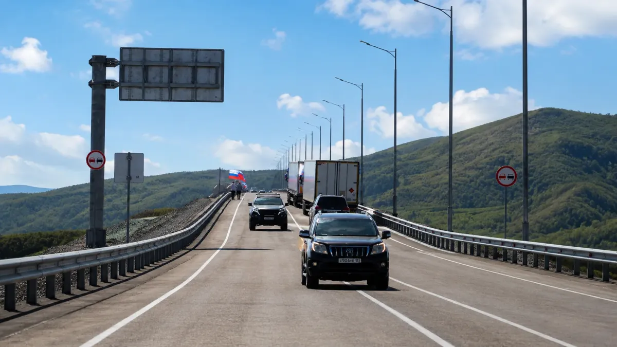 Civilian vehicles cross the first road bridge between Russia and North Korea during its September 7 opening.
