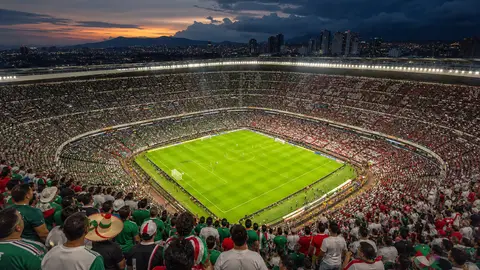 Generic World Cup stadium scene in Mexico City at dusk with storm clouds beyond the lights
