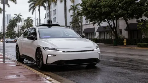 Generic editorial image of an autonomous electric car at a Miami curb on a rainy street