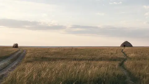 Two paths crossing a broad prairie between a distant wagon and lodge