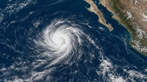 Satellite-style editorial image of Tropical Storm Elida over the eastern Pacific, far southwest of Baja California