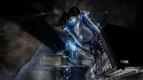 Starship standing on the Starbase launch mount at night in an official SpaceX source-photo crop.
