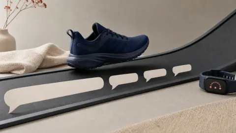 A training shoe approaches an incline as one long paper speech ribbon breaks into shorter pieces beside an unbranded fitness watch.