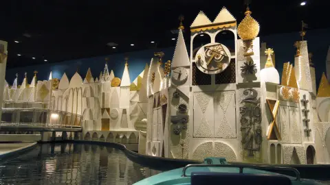 A quiet, source-grounded wide view of the distinctive It’s a Small World clock facade and empty loading water at Magic Kingdom