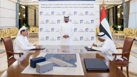 DP World and Fujairah Ports Authority signing backdrop with cargo-planning objects on a table