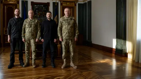 Zelenskyy stands with Ukrainian military commanders in an official room during a command transition.