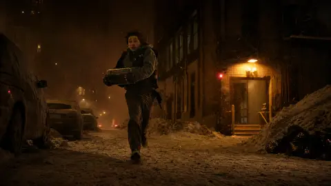 Austin Abrams as medical courier Bryan runs through a snow-gritted night street carrying a hard-shell delivery case.