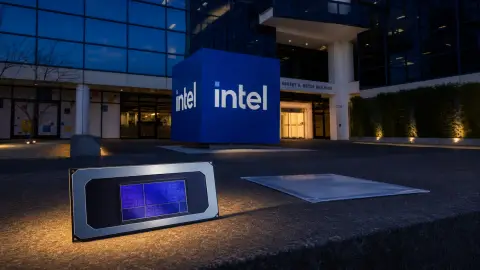 Intel's blue logo cube outside its Santa Clara headquarters, with an Intel processor lit in the foreground beside an unmarked document sleeve.