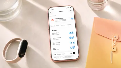 Phone displaying the ChatGPT Health dashboard beside a fitness band and a closed medical-record envelope