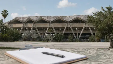 Miami Marine Stadium seen behind a blank ballot packet and pen, suggesting the city referendum over the venue's future.