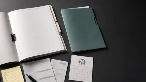 A leave-policy packet, payroll papers, an insurance folder, and a calendar arranged on a desk for review.