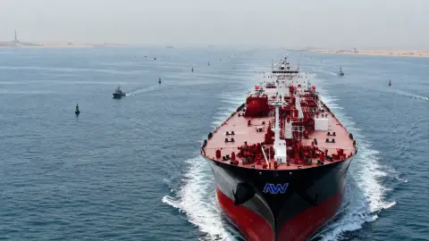 An Abu Dhabi National Oil Company and ADNOC-style tanker moves through open water in a guarded shipping corridor.