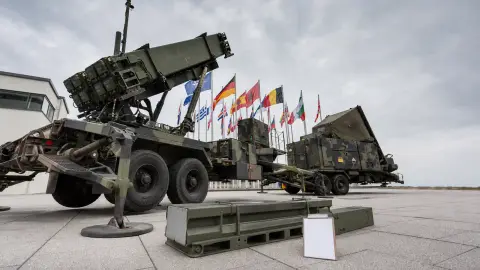 A NATO Patriot launcher beside an unresolved resupply position with one empty equipment cradle